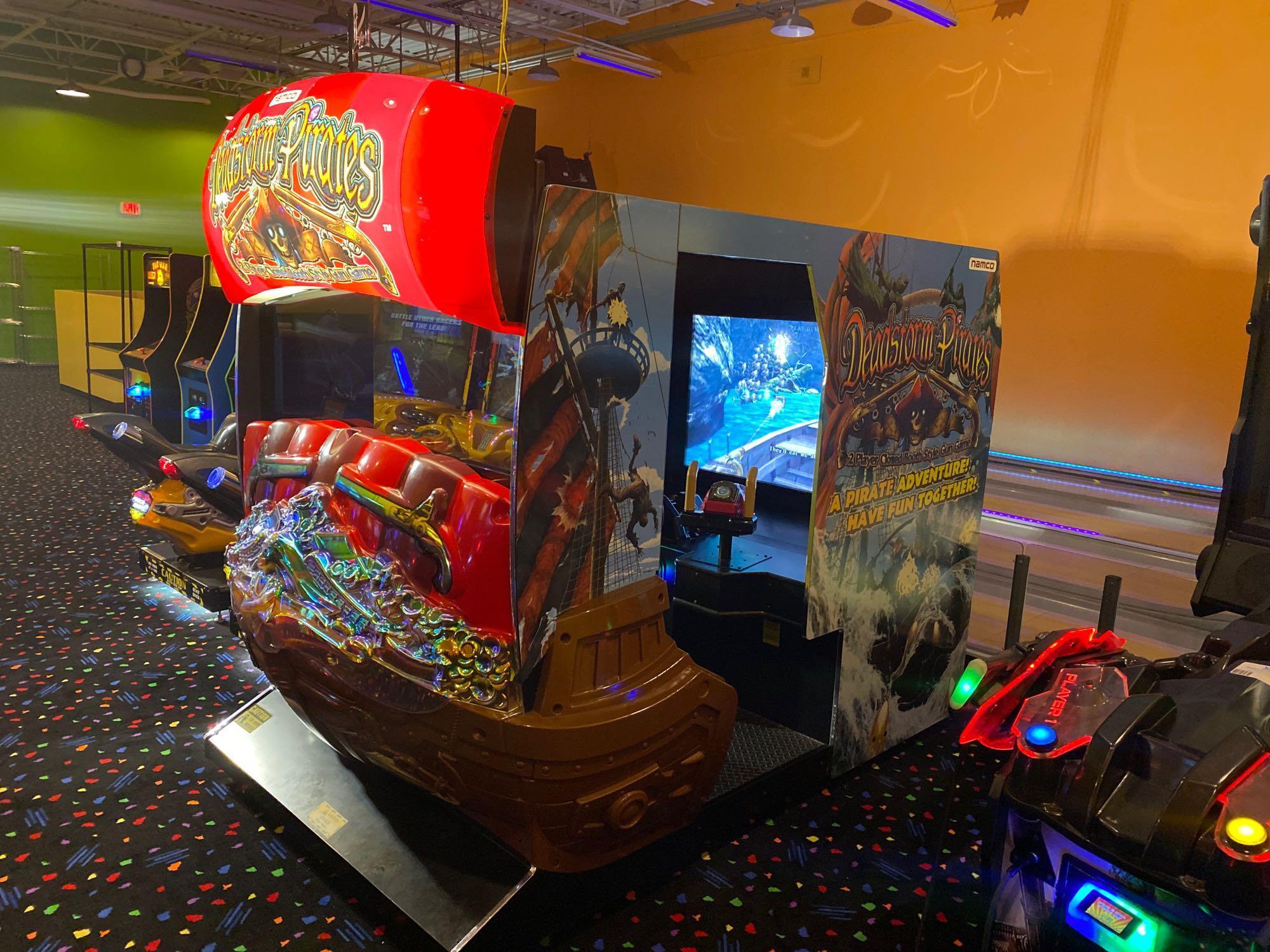 Deadstorm Pirates cabinet on a carpeted arcade floor, with other games beside it